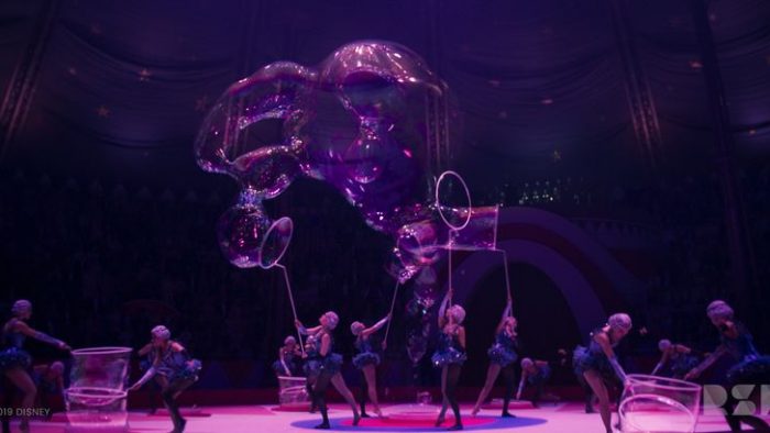A circus scene of performers with giant bubble blowers