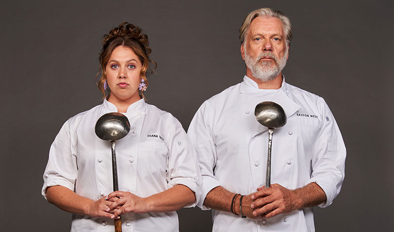 Natalie Abbott and Erik Thomson standing side by side wearing chef's whites and holding ladles