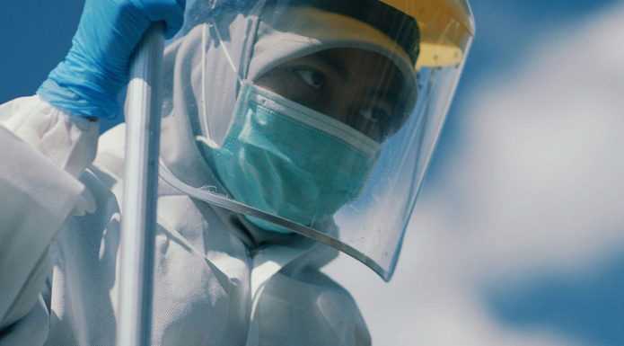 Close up of a person wearing a hazmat suit and facemask