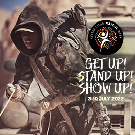 Shantae Barnes Cowan as Shanika in Firebite wearing a dusty hoodie and holding a rope, with the NAIDOC Week logo over the top and words reading "Get up stand up show up"
