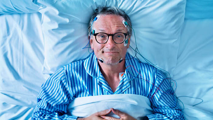 Dr Michael Mosley lying in a bed smiling