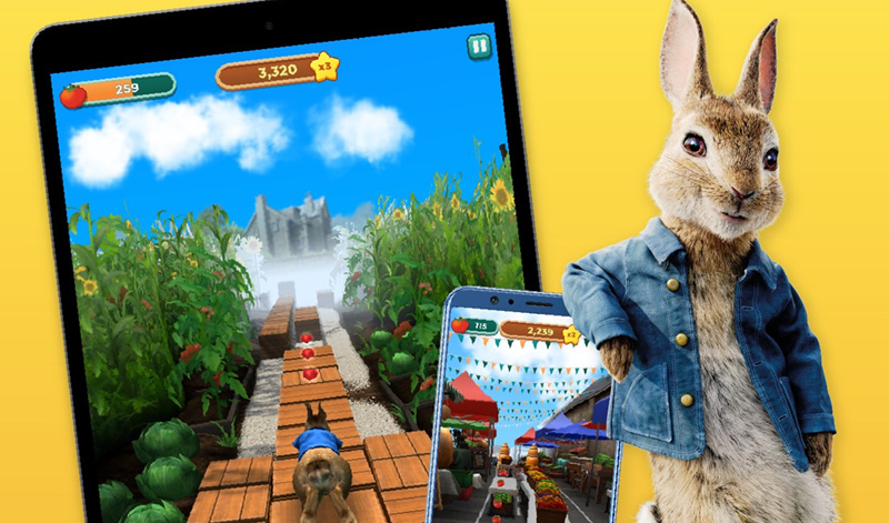 Peter Rabbit pictured with two devices playing the game Peter Rabbit Run!