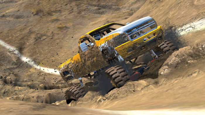 A yellow truck driving uphill through mud.