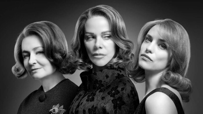 Actors Miranda Otto, Debi Mazar and Jessica De Gouw stand against a plain background in 60's style fashion and hair-dos. The image is in black and white.