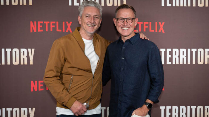 Territory Director Greg McLean and South Australian Territory Producer Paul Ranford stand in front of a black backdrop with the Netflix and Territory logos on it.