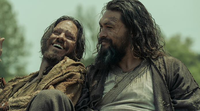 Two men laugh together.